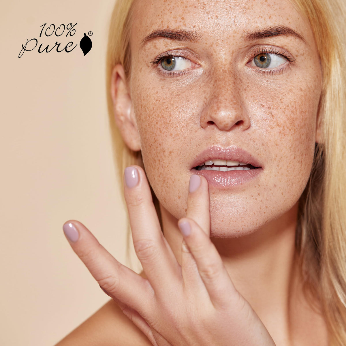100% PURE lip balm held in hand showing compact size for on-the-go use