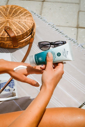 Absolutely Natural 3 oz tube beside sunglasses showing compact travel-friendly benefit