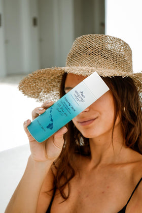 Absolutely Natural bottle beside hand showing 8 fl oz scale and portability