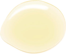 Hand applying Acure argan oil to hair ends to reduce frizz and add shine