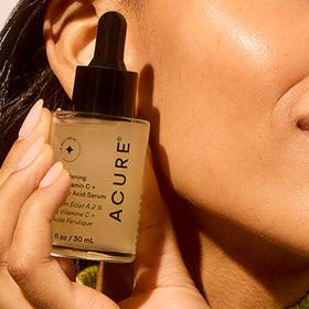 Acure applying serum on hand to show smooth spreadability and hydration
