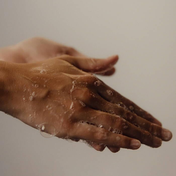Aesop hand balm spread on back of hand demonstrating fast absorption and instant softening