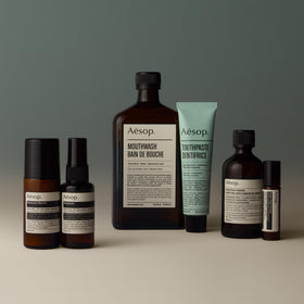 Aesop roll-on next to a coin for size comparison emphasizing travel-friendly 1.6 oz