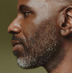 Applying Aesop oil to beard for softer, more manageable facial hair
