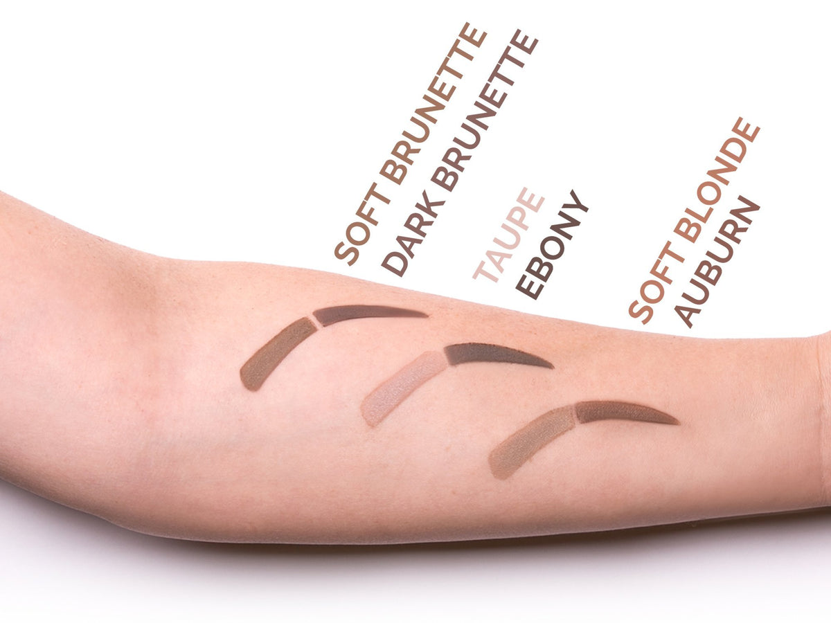 Aesthetica model applying brows using mirror for quick touch-ups and refined arches