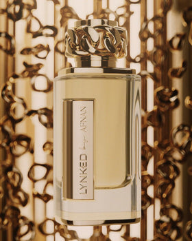 Afnan Lynked Forever Gold flatlay with mandarin and flowers showing scent ingredient story