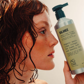 AG Care bottle on bathroom vanity, suggesting everyday natural haircare routine