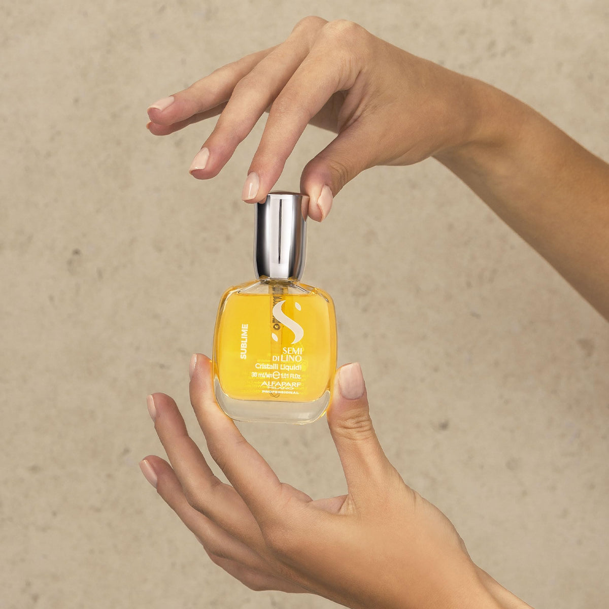 ALFAPARF MILANO bottle beside a hand highlighting travel-friendly compact size