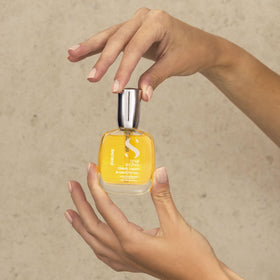 ALFAPARF MILANO bottle beside a hand highlighting travel-friendly compact size