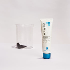 Andalou Naturals moisturizer held in hand to show compact 2.1 fl oz size and travel convenience