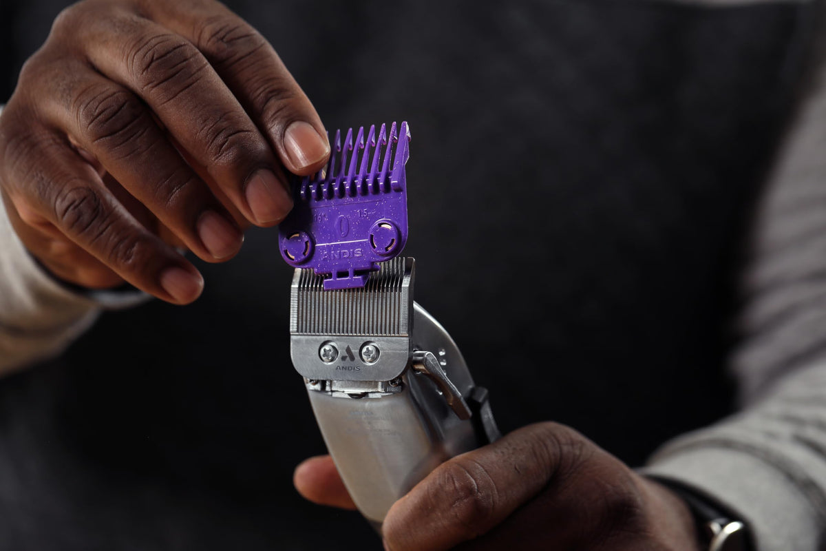Andis combs held in hand for scale, showing compact professional guard sizes