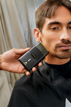 Andis shaver in hand for scale to show compact size and travel-friendly portability