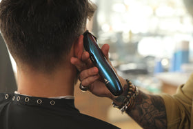 Andis Slimline Pro size comparison next to clipper showing compact professional scale