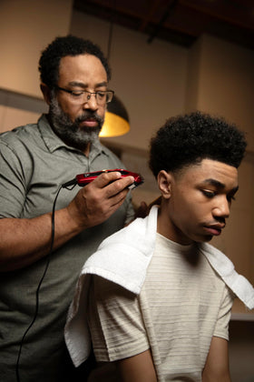 Andis Ultra Clip in use at a barber-style home haircut showing controlled, quiet trimming