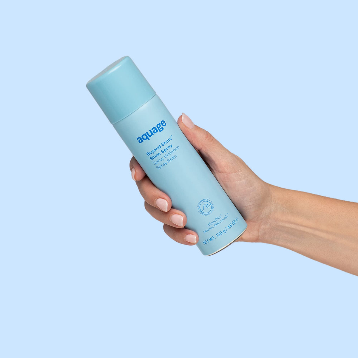 Hand holding Aquage 4.6 fl oz bottle to show scale and travel-friendly size