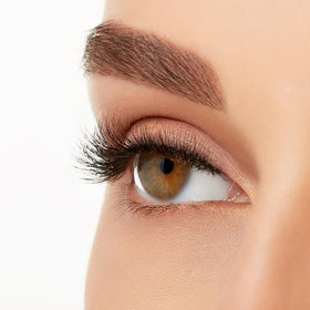 Ardell lashes beside a coin to show scale for accurate length