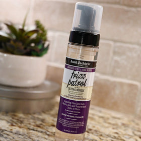 Before and after hair comparison using Aunt Jackie's mousse showing reduced frizz and shine
