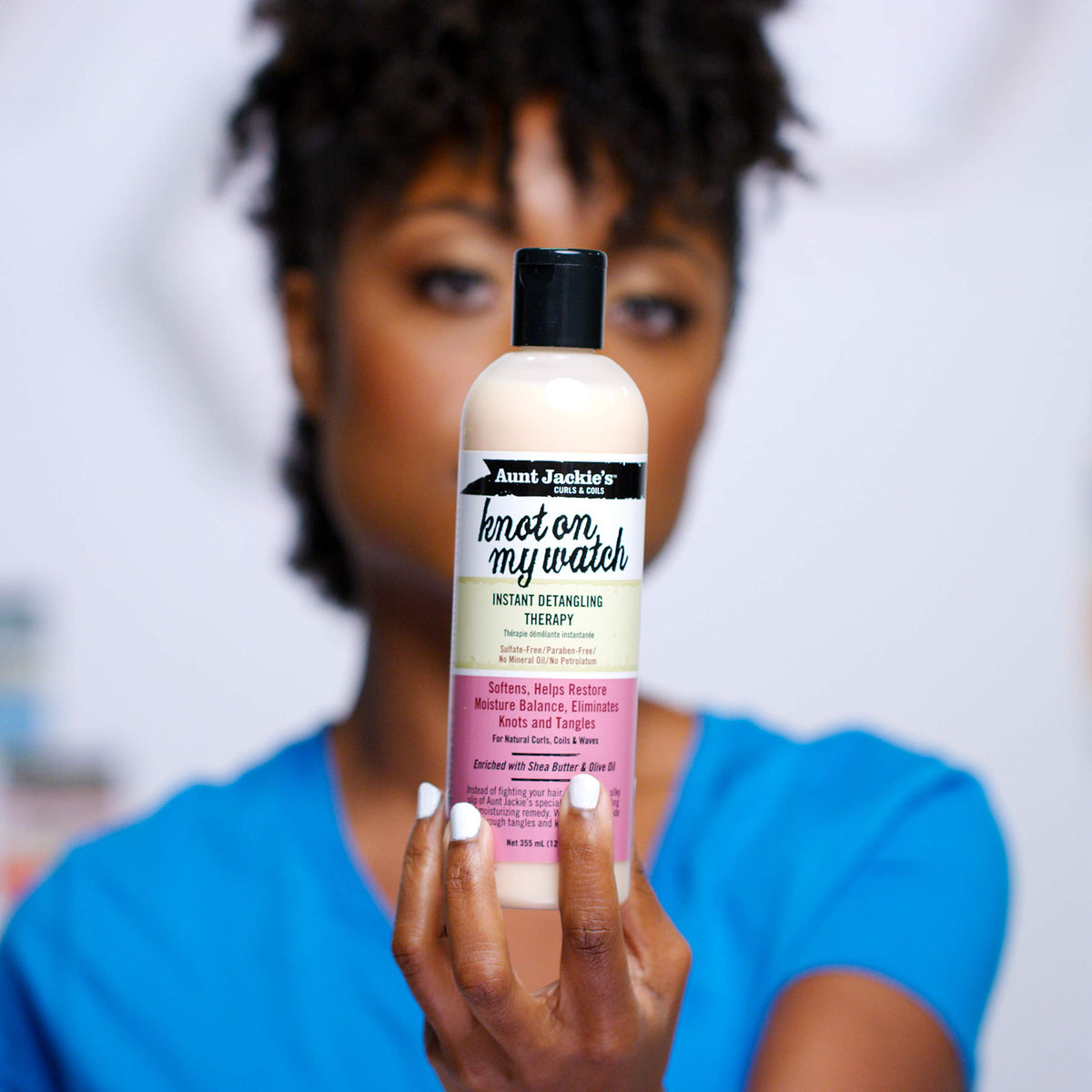 Aunt Jackie's detangler cream on fingers showing smooth consistency for instant slip
