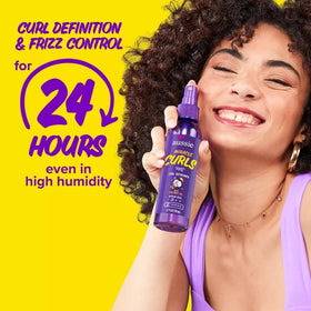 Aussie spray applied to dry curly hair to revive definition and reduce frizz