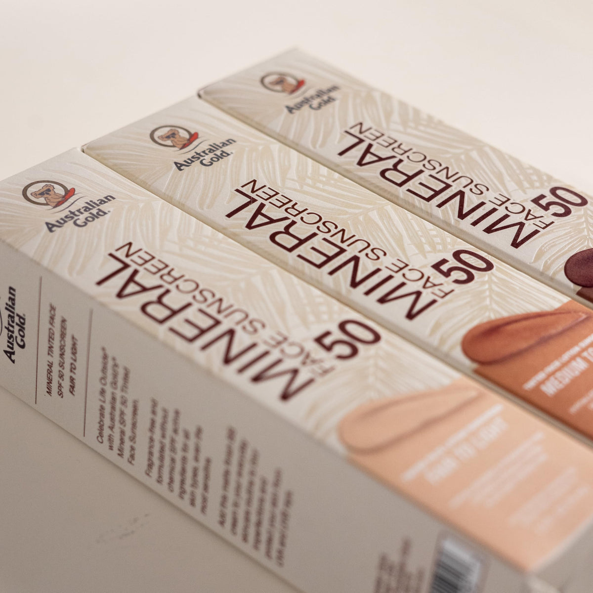 Australian Gold tube pictured outdoors emphasizing sun protection benefits