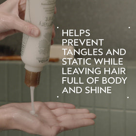 Aveda brand conditioner texture on hand demonstrating lightweight consistency