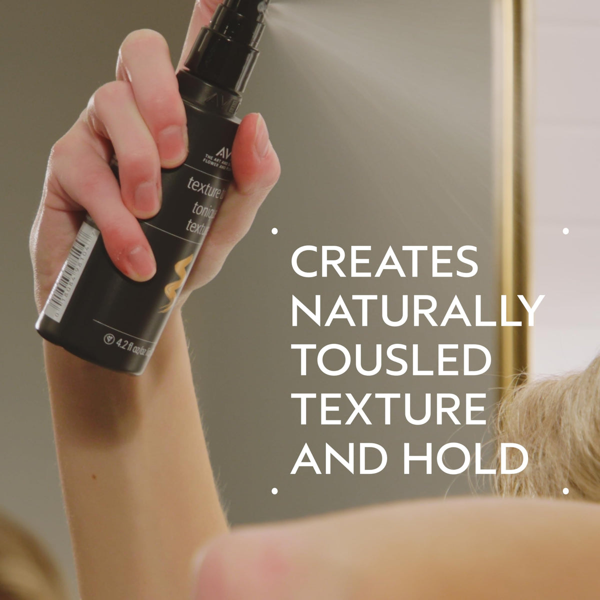 Aveda Texture Tonic mist spraying from nozzle, demonstrating even coverage for effortless styling