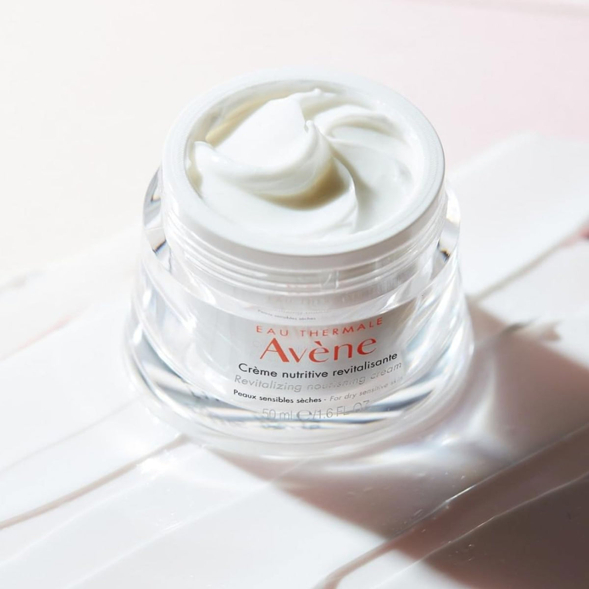 Avène 1.6 oz jar beside a ruler showing compact size benefit: travel-friendly