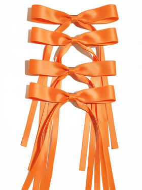 Ayesha orange bow front view showing neat bow shape and long ribbon tail, adds vibrant color