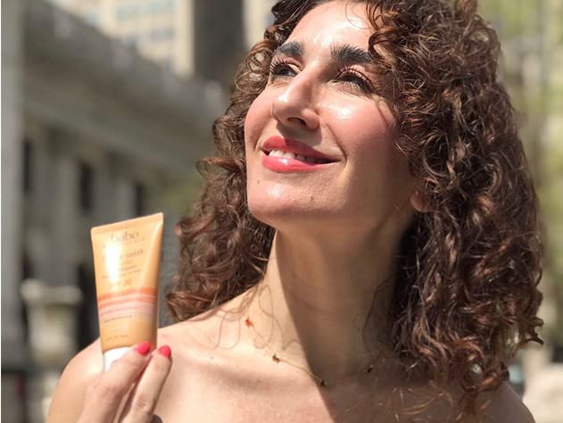 Babo Botanicals tube in hand showing travel-friendly size and ease of use