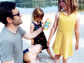 Babo Botanicals bottle in hand to show 6-ounce size and portability