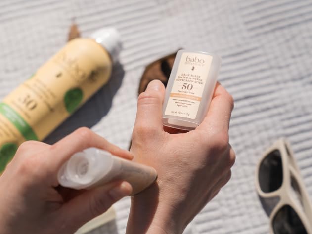 Babo Botanicals stick held in hand to show pocket-sized convenience benefit