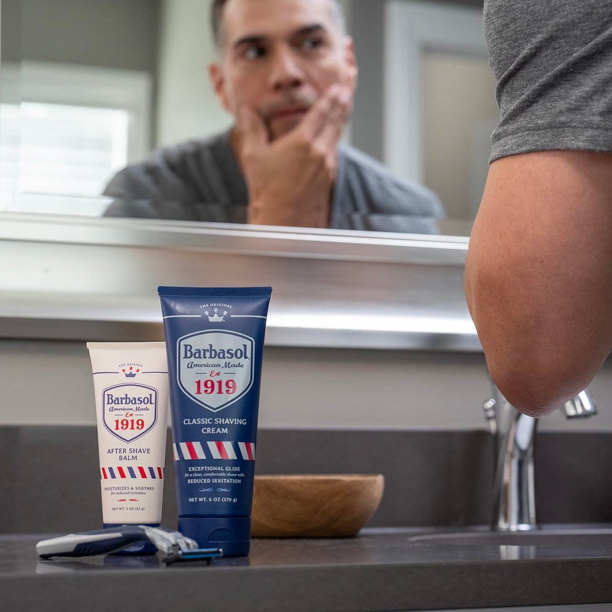 Barbasol 1919 on a bathroom shelf with grooming items, suggesting daily post-shave routine