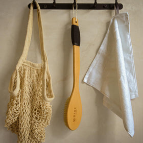 Bare Botanics in-shower use with water showing wet exfoliation and stable handling benefit