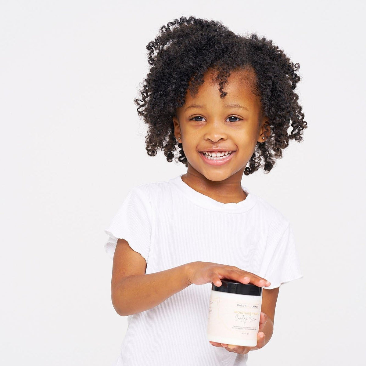 BASK & LATHER applied in curly hair showing defined, frizz-reduced results