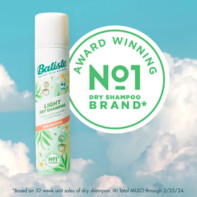 Person spraying Batiste at roots to quickly refresh hair between washes
