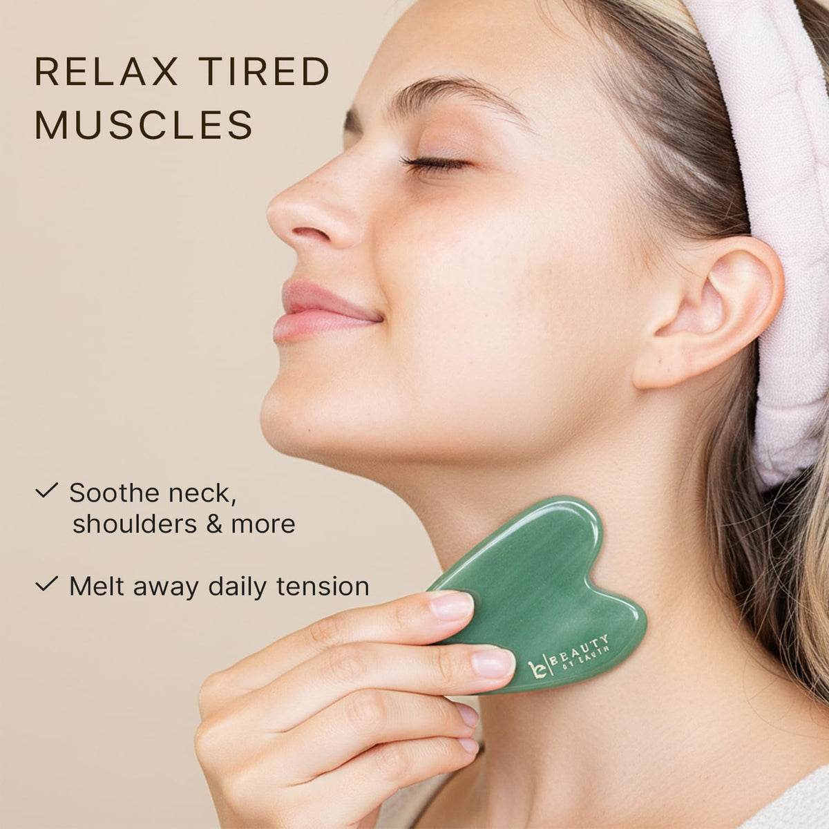 Beauty by Earth tool held against cheek to show size and ergonomic fit for jawline sculpting