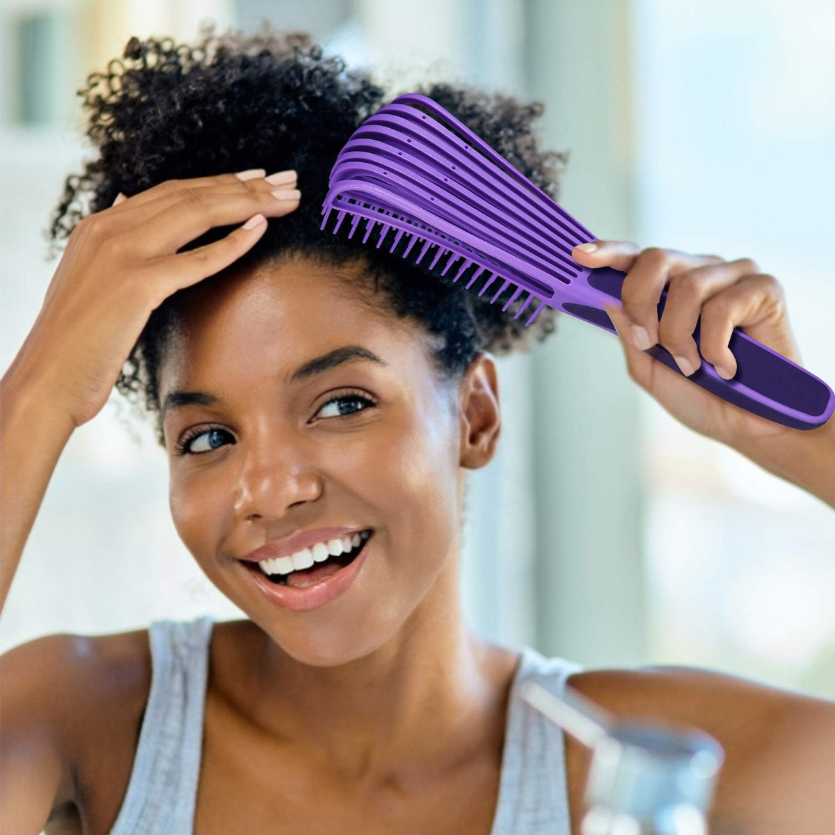 BESTOOL brush being used on damp curly hair to reduce tangles and preserve curl pattern