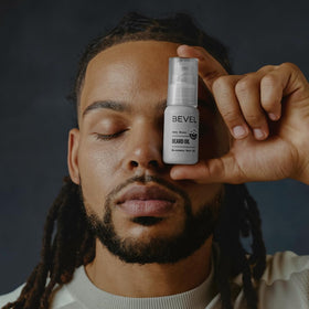 Bevel beard oil bottle beside beard comb, conveys styling and softening benefit