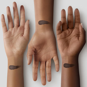 Black Radiance foundation stick held in hand for size and portability benefit