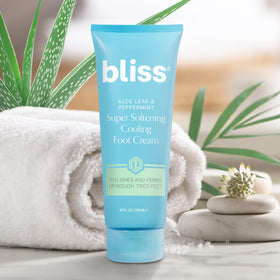 Bliss 4.0 fl oz tube next to a coin for scale showing portable at-home foot treatment