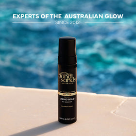 Bondi Sands bottle in hand for scale showing compact travel-friendly size