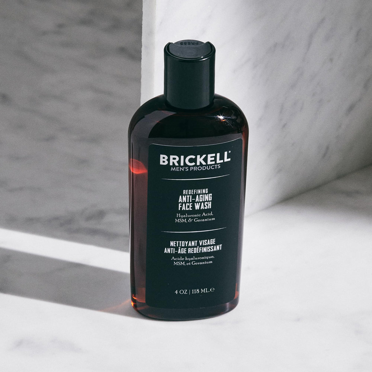 Brickell product in use as man washes face showing easy integration into daily grooming benefit
