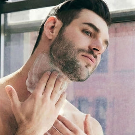 Brickell Men's cream being applied to a male jawline showing use benefit: targeted firming