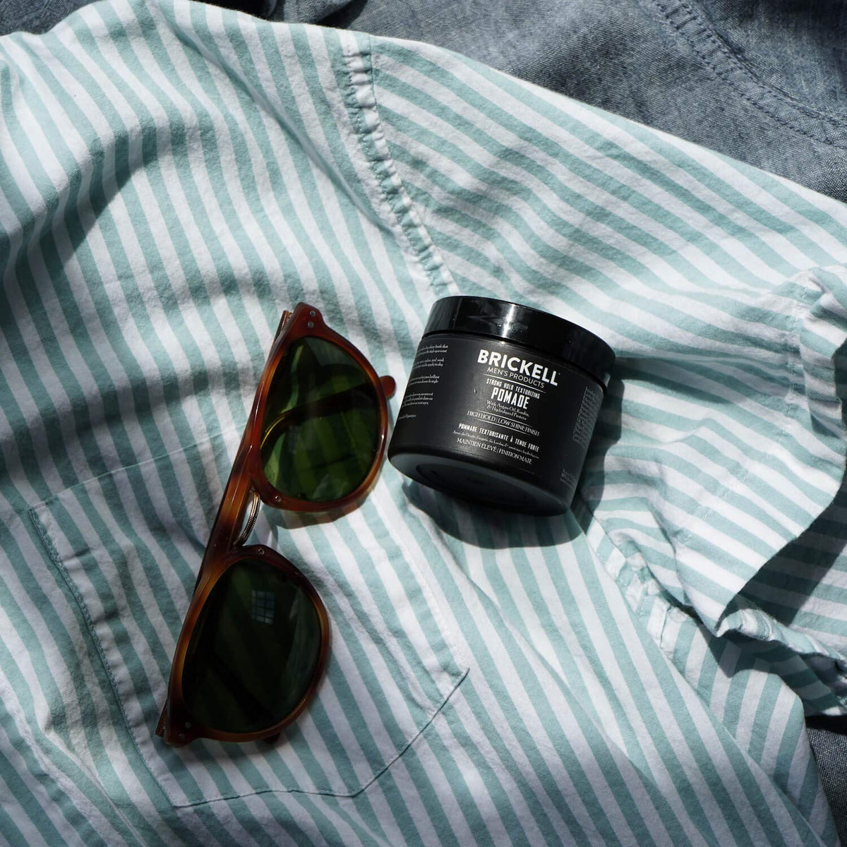 Brickell Men’s Products pomade on hands demonstrating easy warming and even application