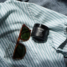 Brickell Men’s Products pomade on hands demonstrating easy warming and even application