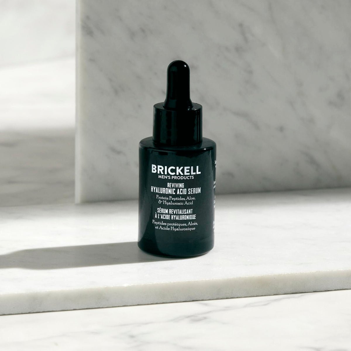 Brickell Men's Products bottle held in hand to show 1 oz scale and travel-friendly benefit