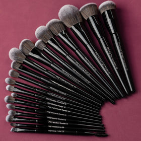 Bueart Design brushes held in hand showing scale and practical size for travel