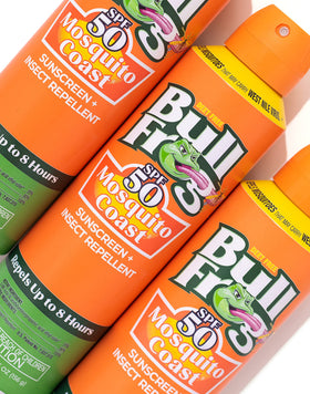 Person applying Bullfrog spray at the beach for sun and insect protection
