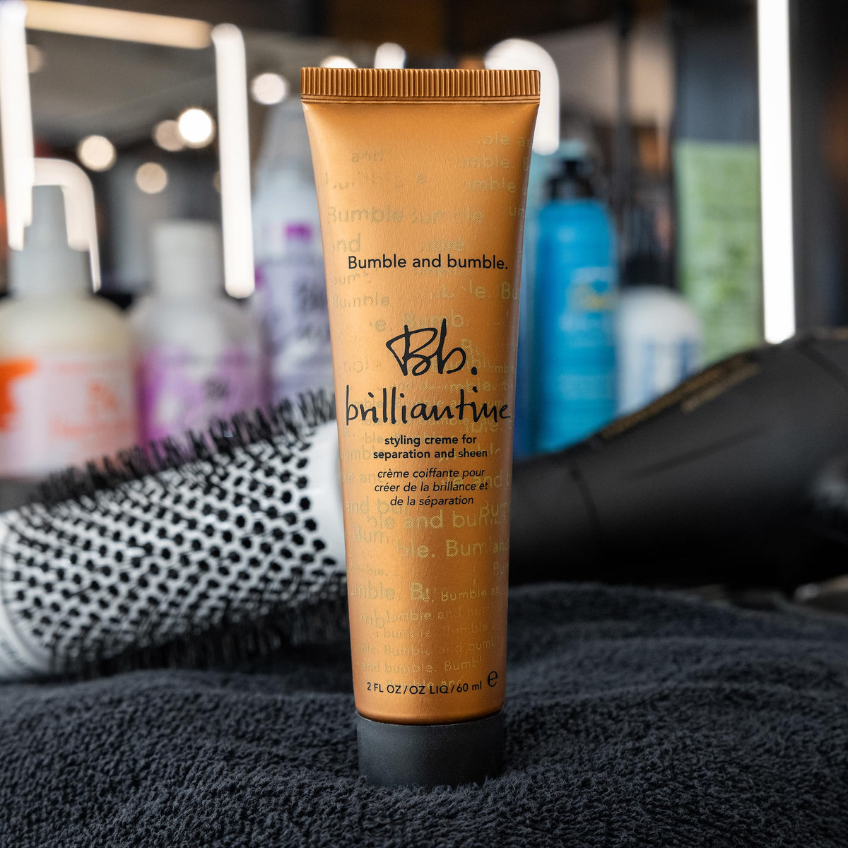 Bumble and bumble 2 fl oz tube beside a coin scale for travel-friendly size and convenience