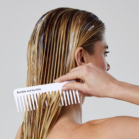 Bumble and bumble conditioner being applied to hair for detangling benefit